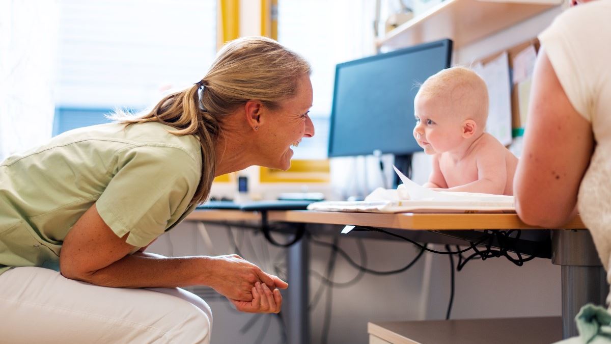 Helsesykepleier som ser på baby på Asker helsestasjon