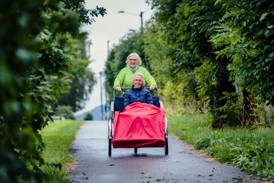 Frivillig på sykkeltur med beboer i bo- og omsorgssenter