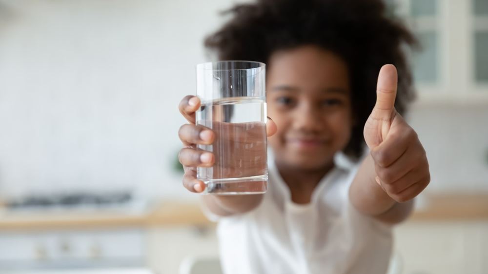 Barn som holder vannglass