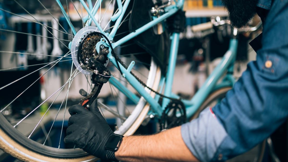 En som reparerer sykkel 